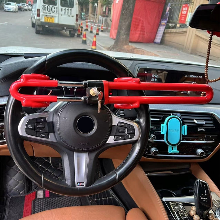 Red steering wheel anti-theft lock mounted across steering wheel with key in housing