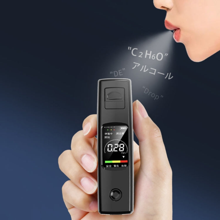 Black alcohol tester held by hand near mouth with LCD reading