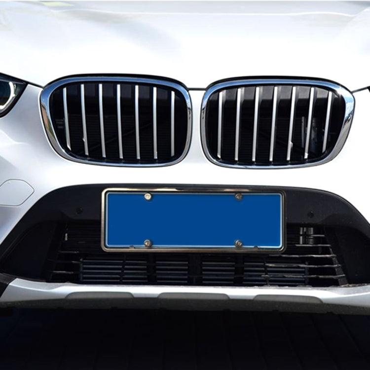 Installed silver license plate frame bracket on a car front grille area