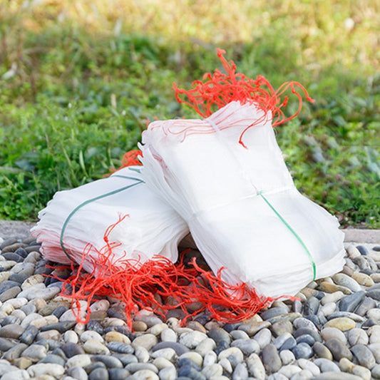 Set of white nylon mesh bags bundled on stones, holding garden items