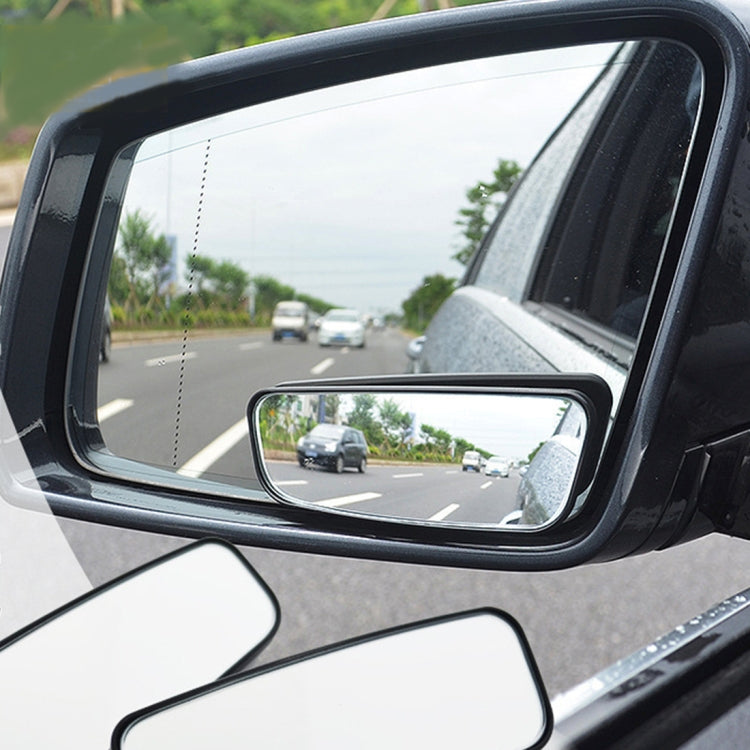 Pair of black wide-angle blind spot mirrors mounted on car side window
