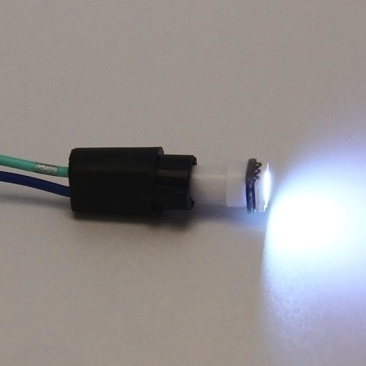 Car bulb holder adapter with black connector and lit bulb at the socket end