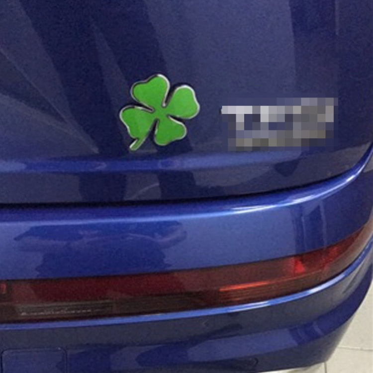 Four-leaf clover emblem sticker on blue car trunk, green clover with chrome edge