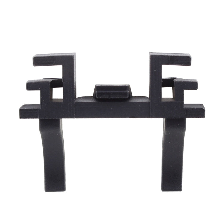 Close-up of black plastic headlight bulb retainer adapter with two side legs
