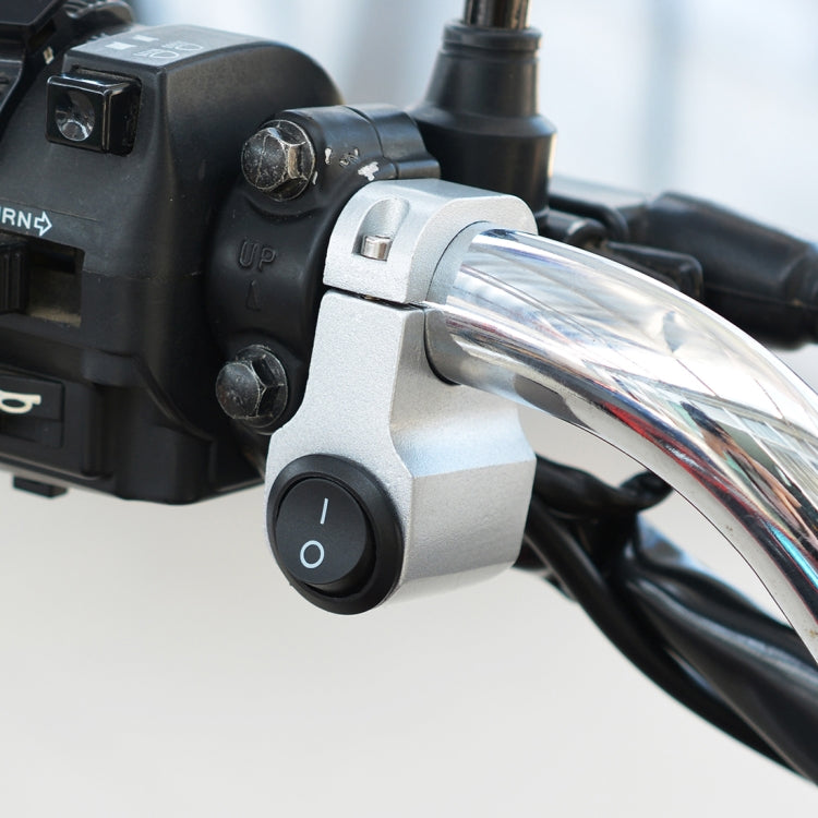 Headlight auxiliary switch with black 0/I button and silver clamp mount on handlebar