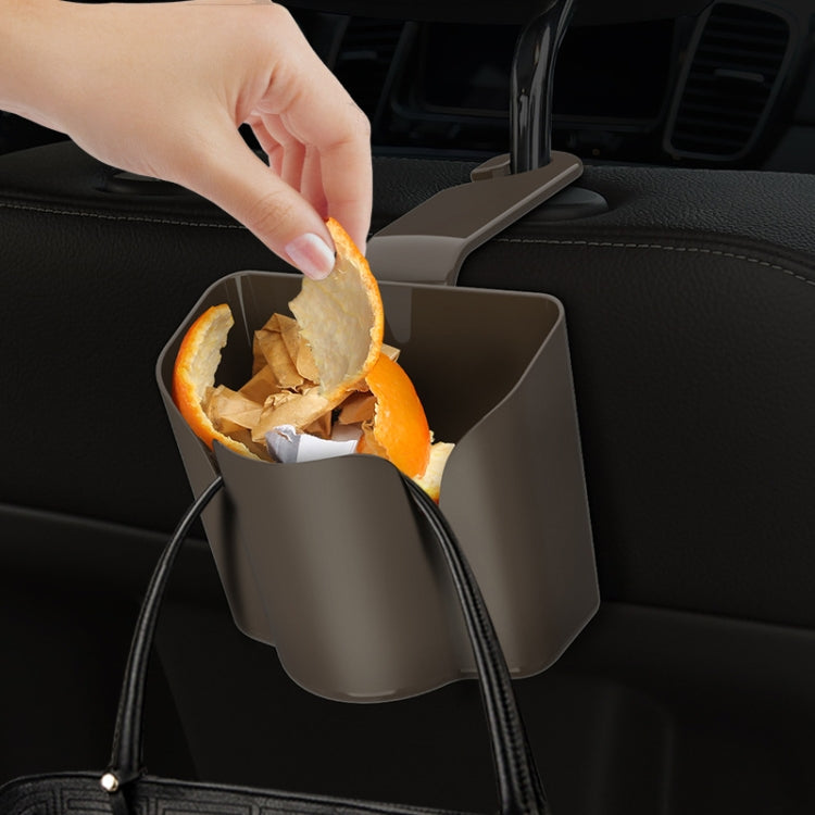 Car back seat hanging trash bin, hand dropping orange peel into open bin
