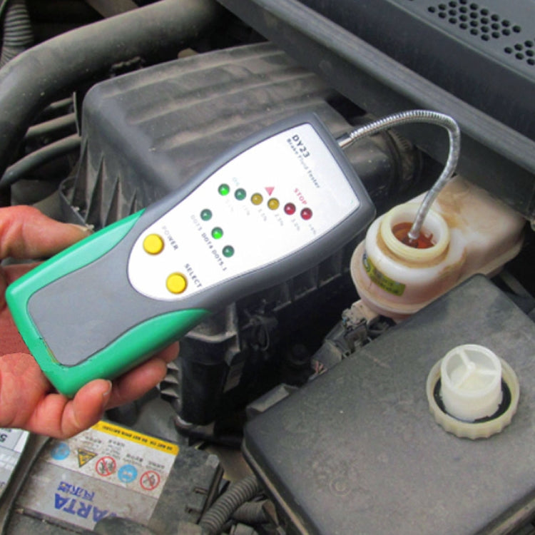 Hand using a brake fluid test pen on an engine reservoir with probe inserted