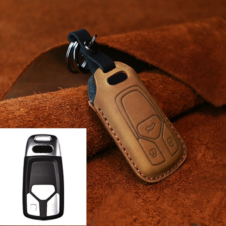 Tan leather key fob cover with key ring and embossed button icons, stitched border