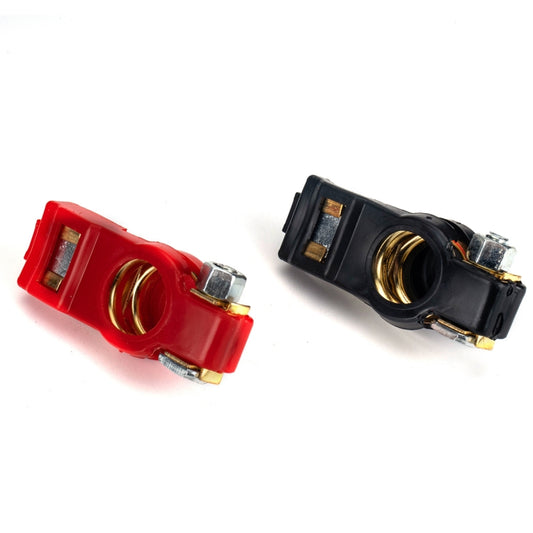 Battery terminal clamps, red and black clips with exposed brass contacts and screws