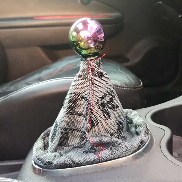 Gray patterned shift knob dust cover with red stitching installed on a car gear knob