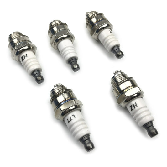 Five spark plugs with white insulators, metal hex threads, and dark center electrodes