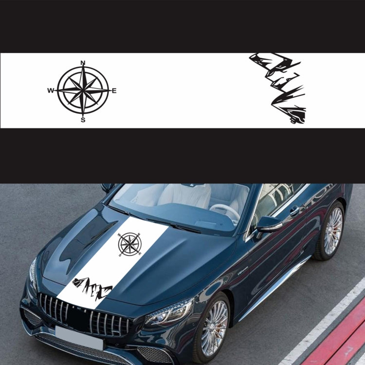 White compass sticker on car hood: black compass rose and jagged mountain graphic.