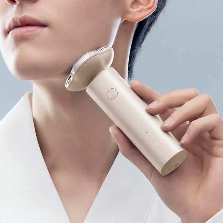 Cream electric shaver in hand shaving neck area