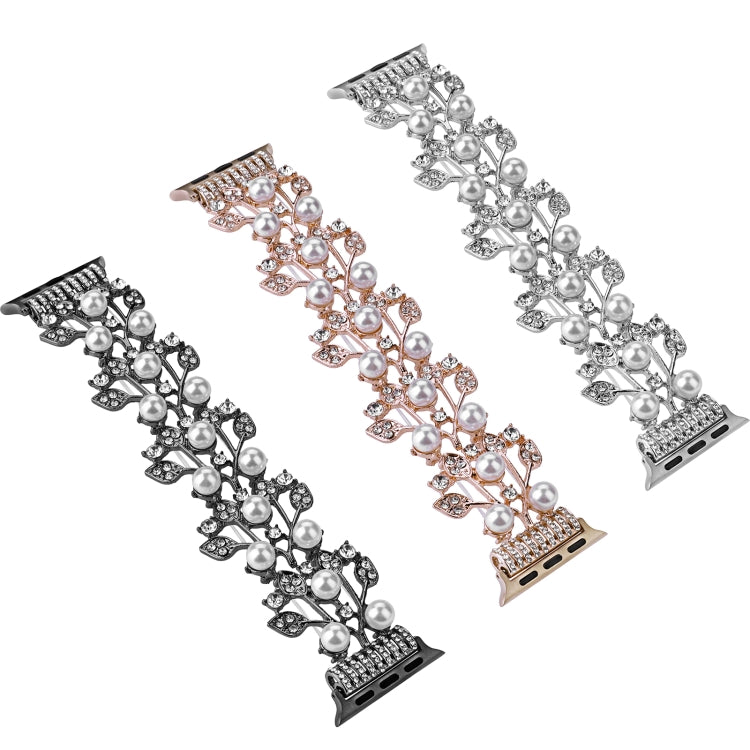Four-leaf metal bead watch band with pearl-like beads and crystal accents, laid flat.