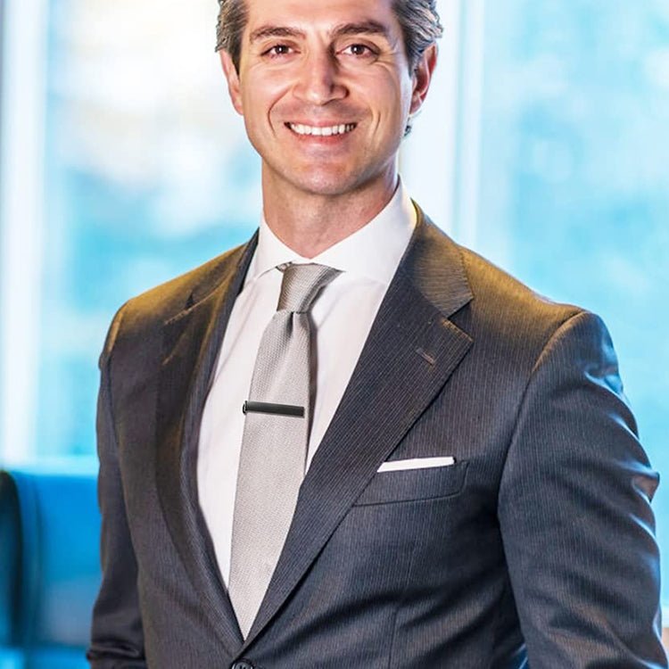 Tie clip on a dark suit and tie, holding the tie in place