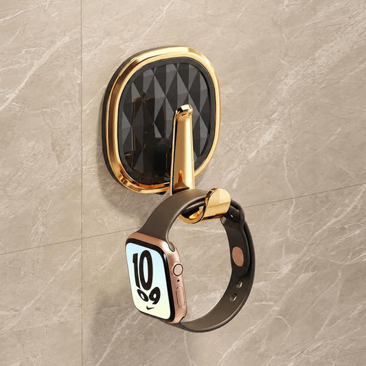 No-drill adhesive wall hook with dark faceted oval backing and gold hook