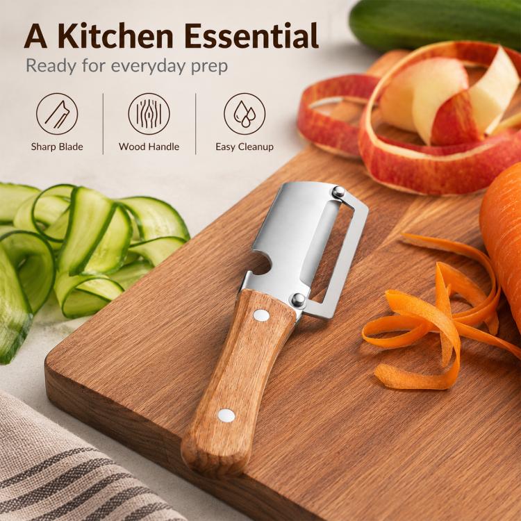 Kitchen peeler with stainless steel blade and wooden handle on a cutting board