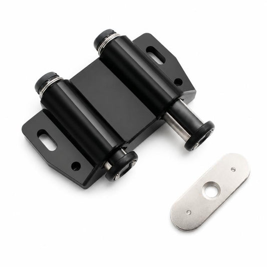 Black handle-free cabinet door latch with metal mounting plate and striker pad