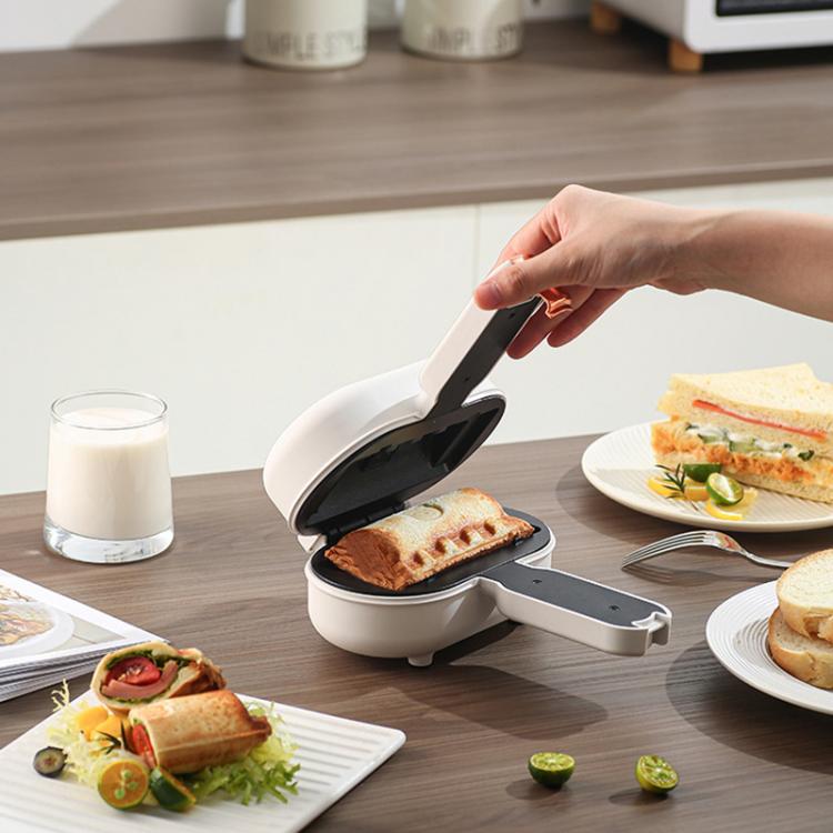 White mini sandwich maker with lid open and sandwich pressed on non-stick plate