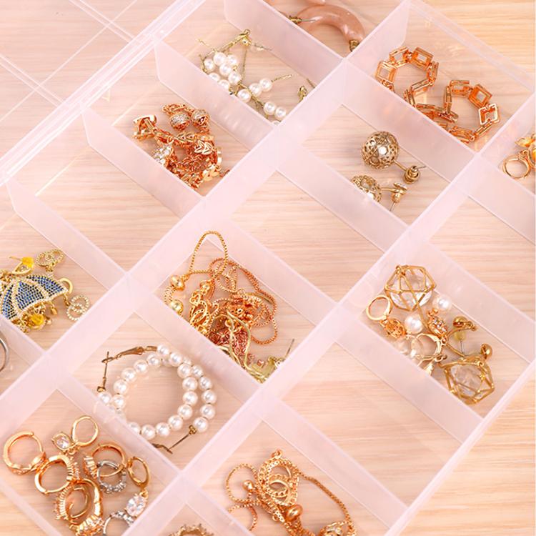 Close-up of clear 18-compartment organizer box filled with gold jewelry and pearl beads