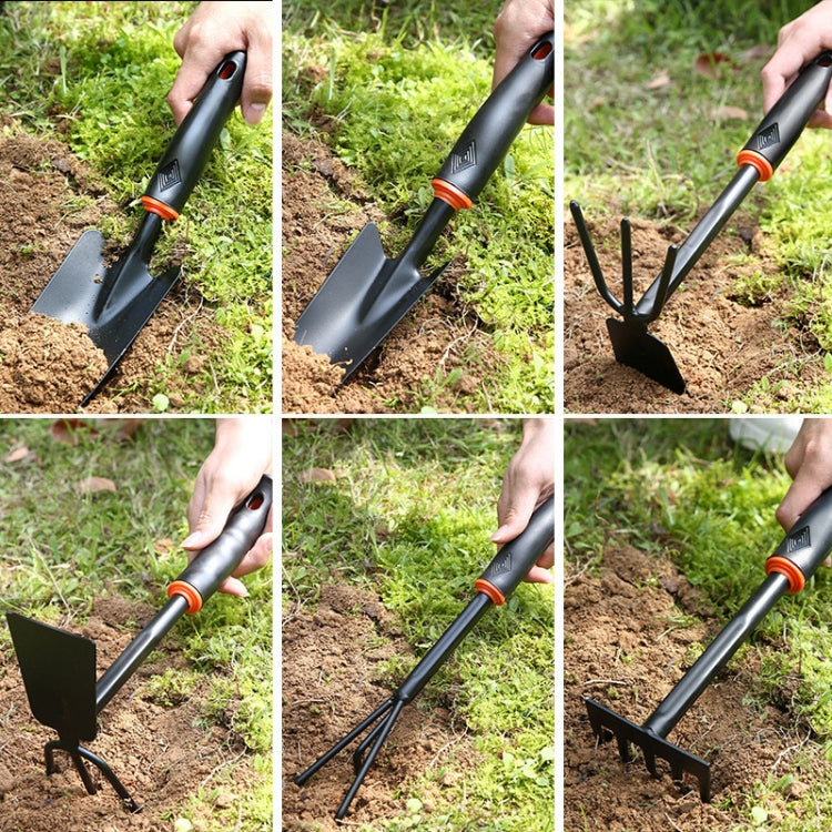 Weeding tool pulling weeds from garden soil; black handle with orange grip ring