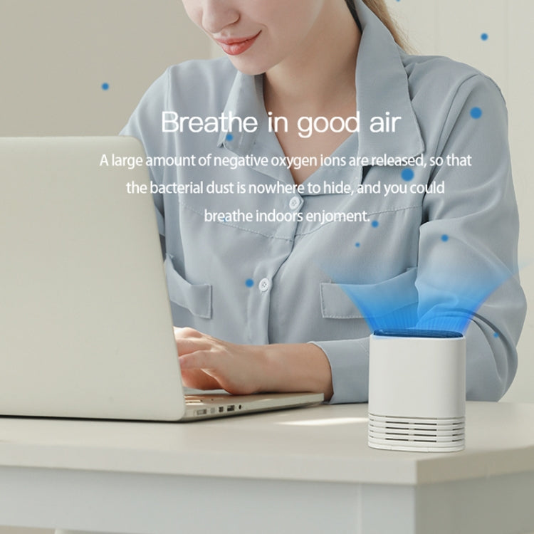 White portable ion air purifier on a desk with black top and front vent grille