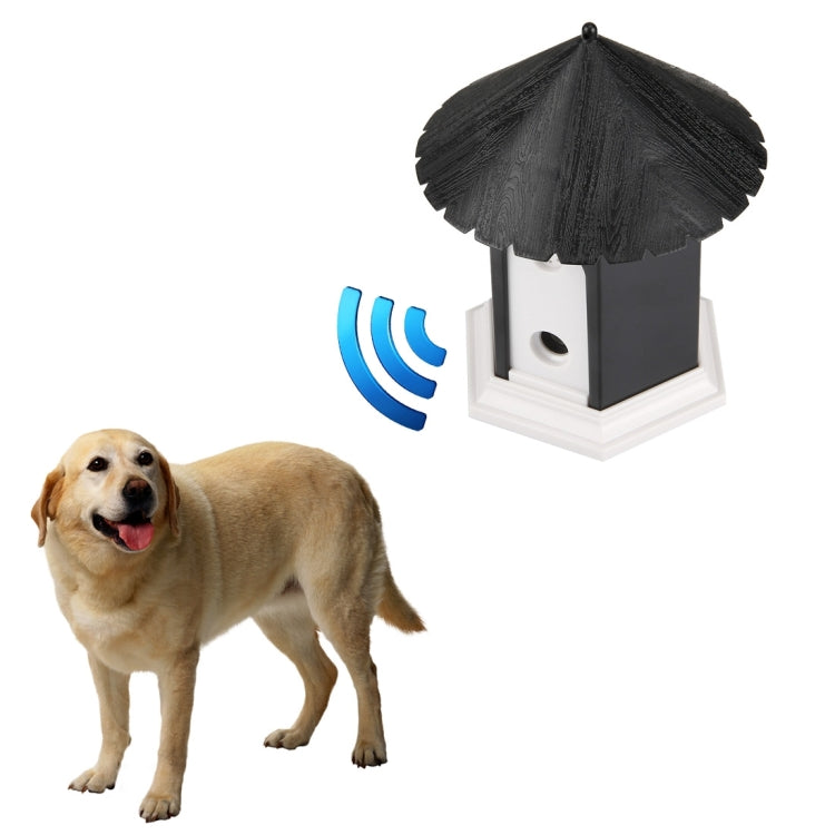 Outdoor bark control training house with sound-wave indicator beside a standing dog