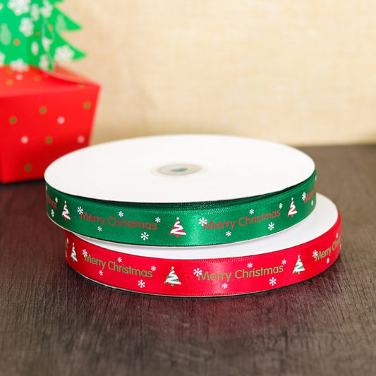 Stacked green and red 'Merry Christmas' ribbon rolls on white spools