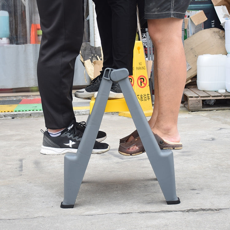 Gray folding step ladder stool with two steps standing on concrete