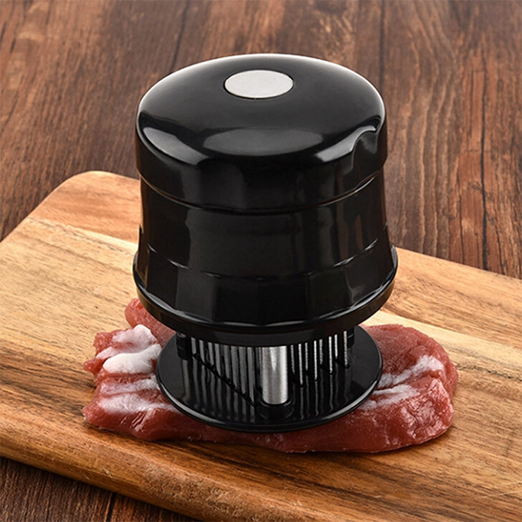 Black stainless 56-pin meat tenderizer with pin drum resting on steak