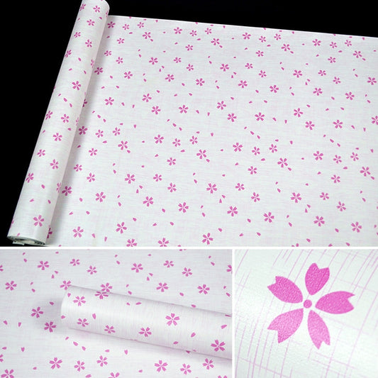 Close-up of cherry blossom wallpaper roll with small pink flower motifs on pale base