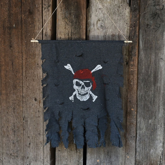 Pirate skull banner flag with red bandana, tattered dark blue fabric and hanging string