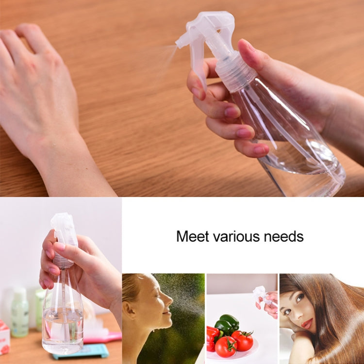 Clear plastic trigger spray bottle with mist nozzle in hand