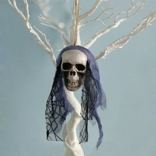 Purple tulle hanging skull ornament with white skeleton face