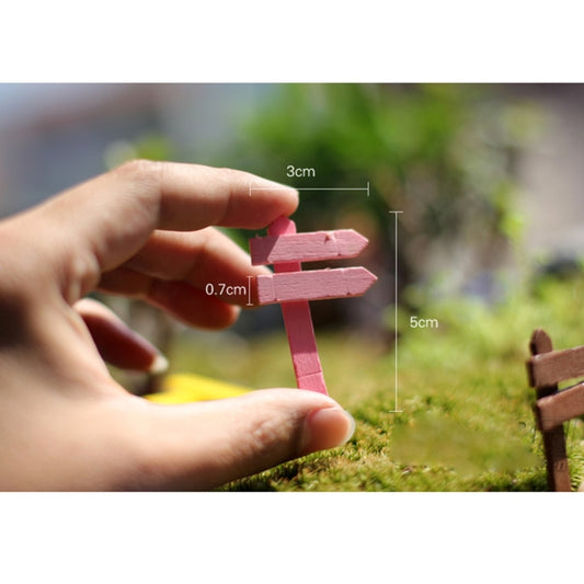 Small wooden fence signpost ornament held in hand, with pink and red rails