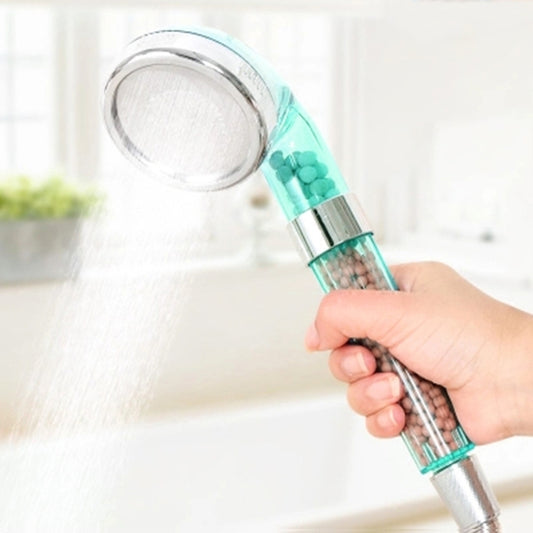 Large shower head with translucent teal handle and chrome spray face, held in hand