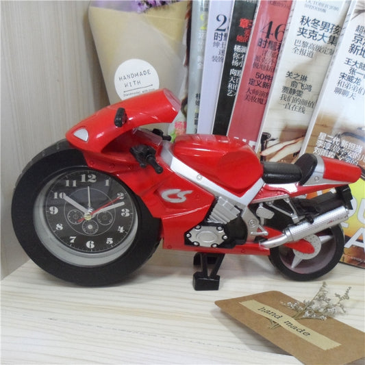 Red motorcycle alarm clock on a shelf, showing round analog dial and engine details