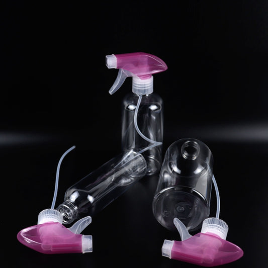 Disinfection spray bottle with pink sprayer head and clear container, angled view