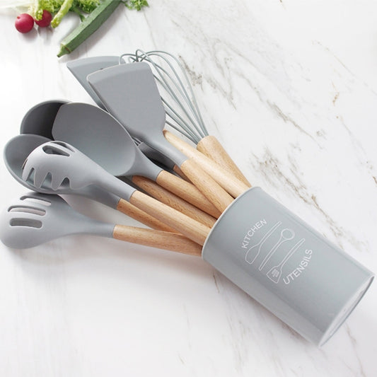 Silicone utensil bucket holding gray kitchen tools with wooden handles