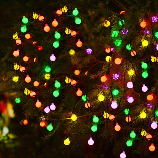 Outdoor solar LED string with round multi-color bulbs on tree branches