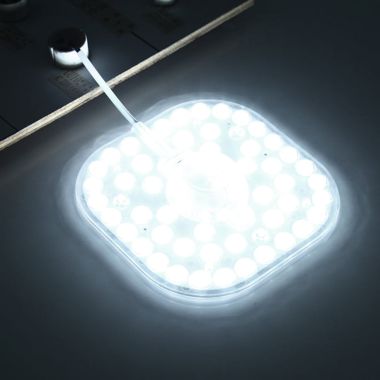 Powered LED ceiling light module glowing with white LEDs and attached lead wire
