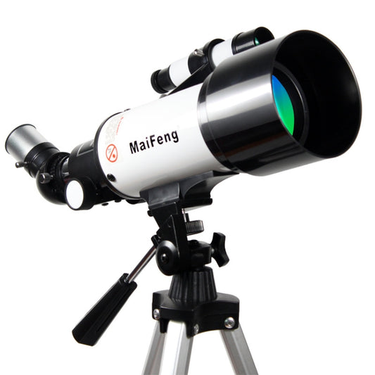 Refracting astronomical telescope with silver tube, black eyepiece and tripod mount