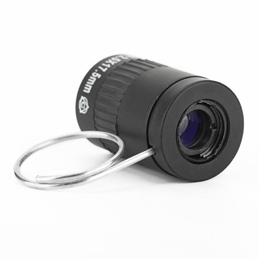Black mini telescope angled view with ridged ring and purple-tinted lens glass