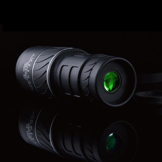 Dark night vision monocular telescope with green objective lens glow.