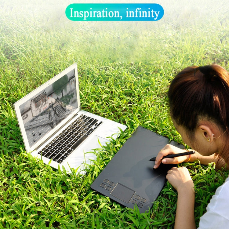 Gray graphic tablet being used with black stylus over a laptop keyboard