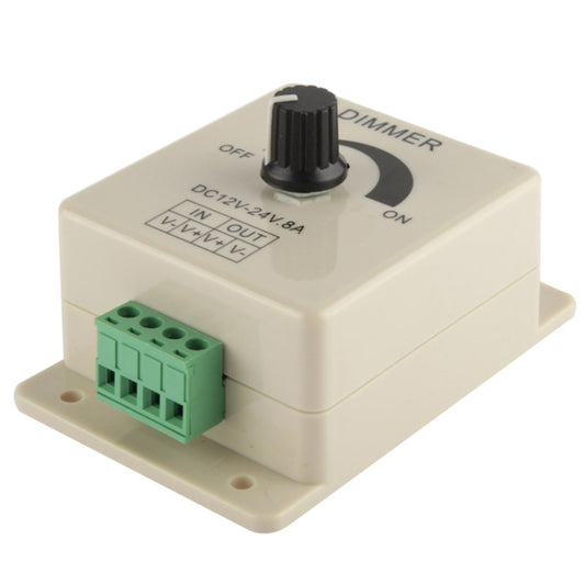 LED dimmer controller with black knob and green terminal block in cream enclosure.