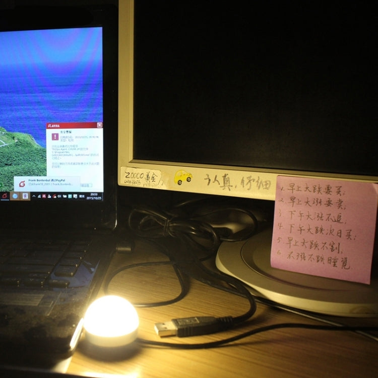 USB mini LED bulb lamp plugged in, emitting warm white light on desk