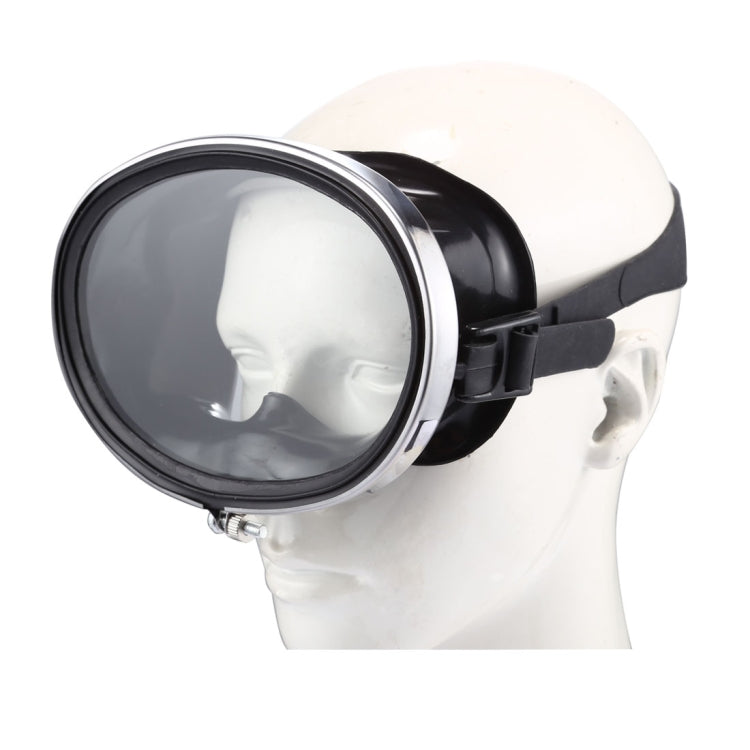Black wide-view dive goggles on head with clear lens and side adjustment strap