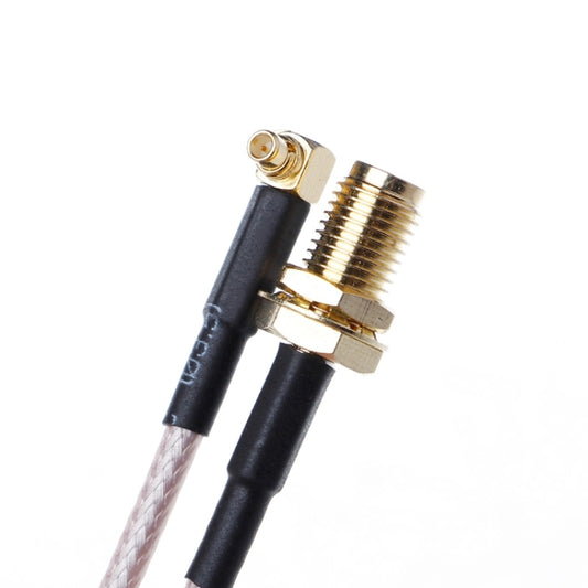 Close-up of braided cable connectors: MMCX male and SMA female with gold hardware
