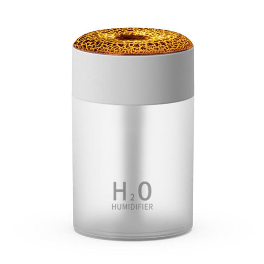 White cylindrical humidifier with gold lava-crack top light and H2O label